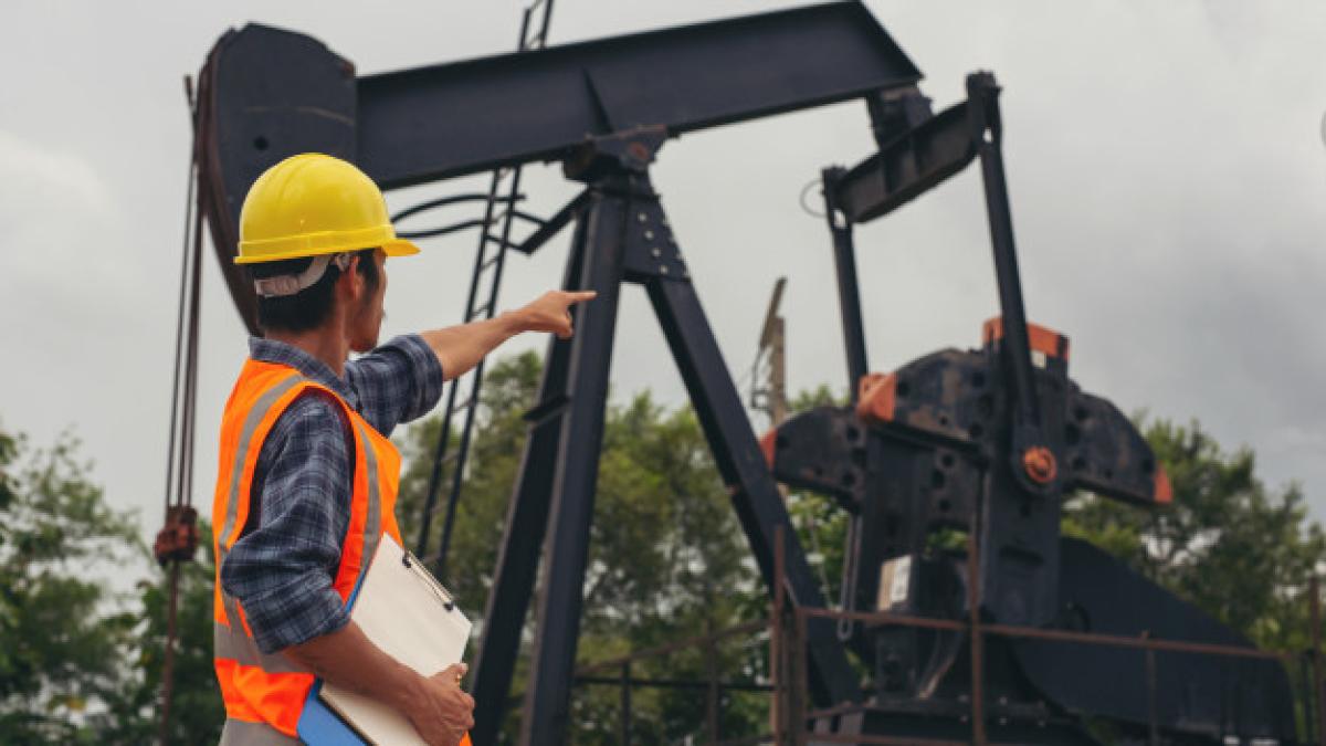 workers_standing_checking_beside_working_oil_pumps_1150_19217_62616800