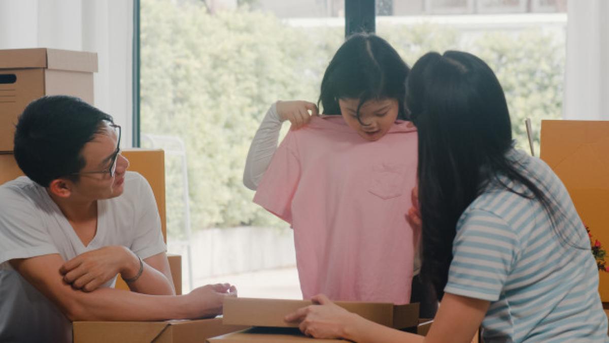 happy_asian_young_family_relocation_removals_settle_new_home_excited_korean_parents_unpack_cardboard_boxes_together_with_little_daughter_holding_clothing_living_room_house_moving_day_7861_2304_37353600