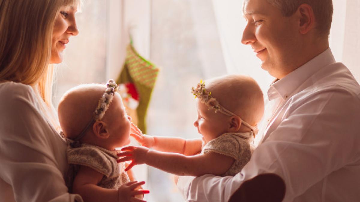 happy_mom_dad_pose_with_funny_twins_their_arms_before_bright_window_8353_319_57373600