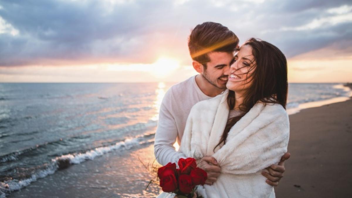 smiling_couple_walking_beach_with_bouquet_roses_sunset_23_2147595923_78962500