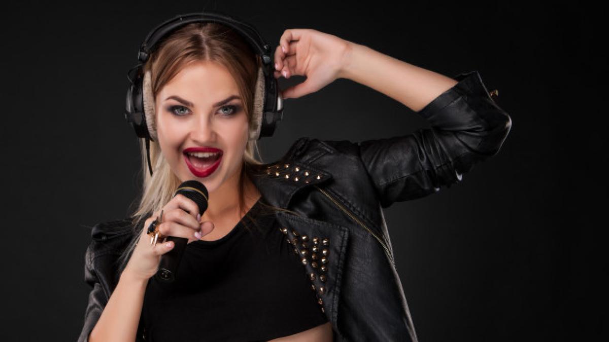 portrait_beautiful_woman_singing_into_microphone_with_headphones_studio_black_background_155003_7578_92795700