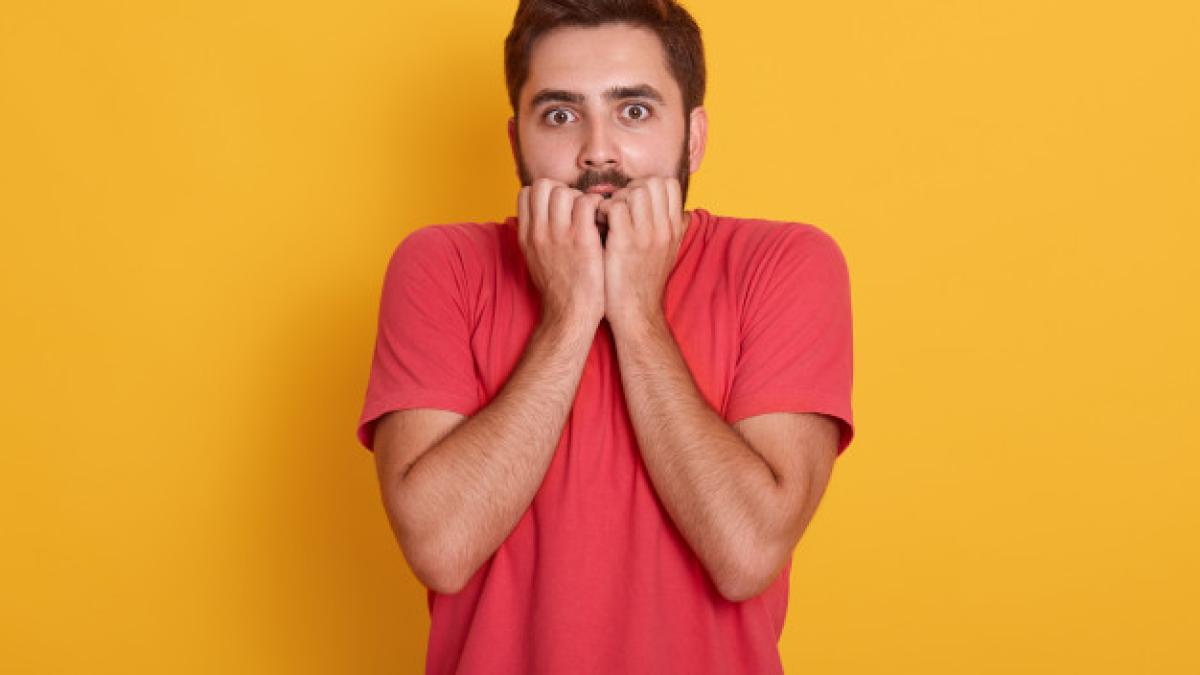 young_man_wearing_red_t_shirt_standing_isolated_yellow_guy_looking_scared_having_amazed_expression_with_hands_chin_bites_his_finger_sees_something_terrible_176532_8841_23668600