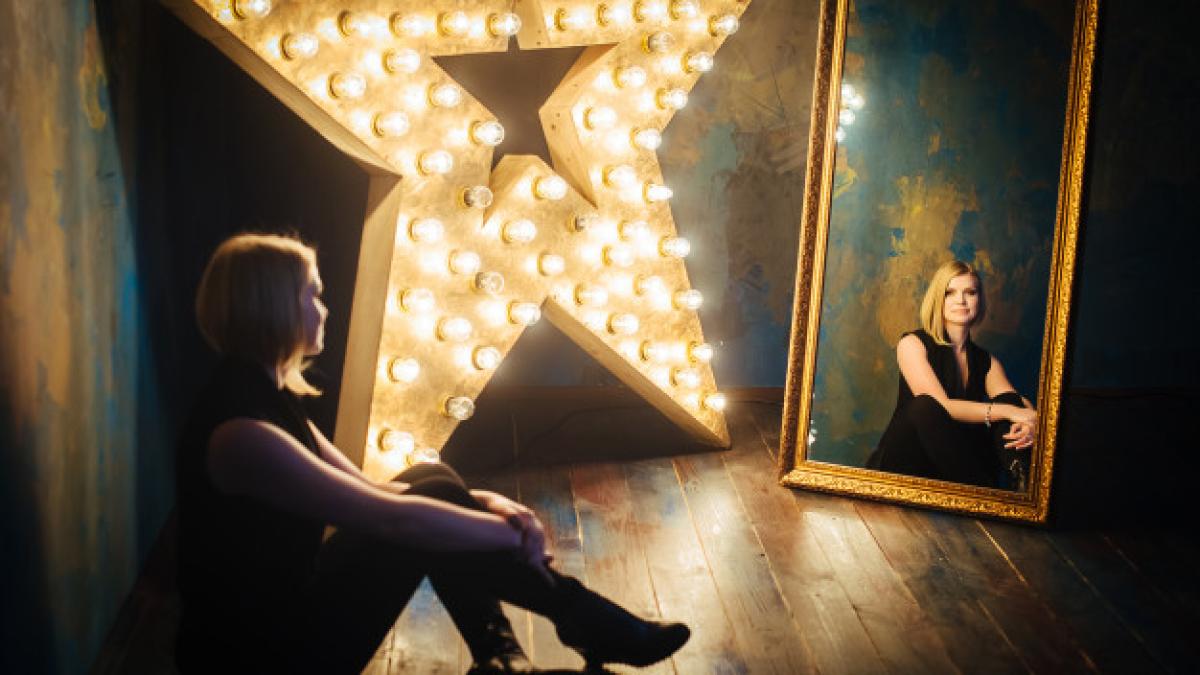 beautiful_blonde_young_woman_black_sitting_floor_background_star_lamps_look_mirror_221769_118_14618000