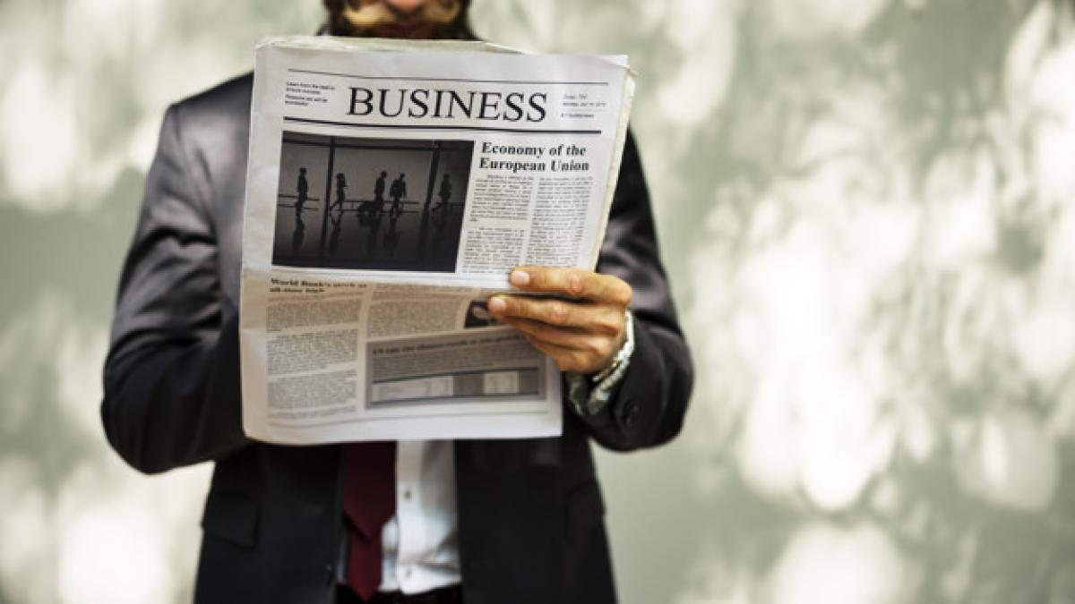 businessman_standing_reading_newspaper_53876_12194_11211900