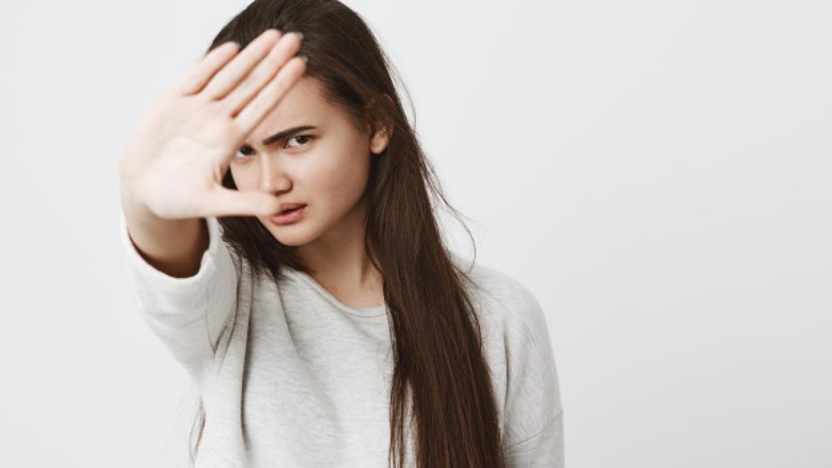 close_up_view_teenage_woman_with_dark_long_hair_making_stop_gesture_with_hand_frowning_face_176420_15299_67151500