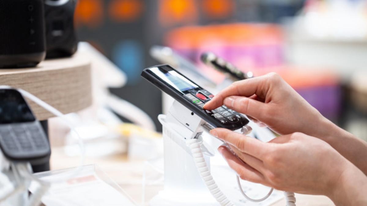 young_woman_store_is_standing_near_stand_choosing_phone_169016_3831_51366900