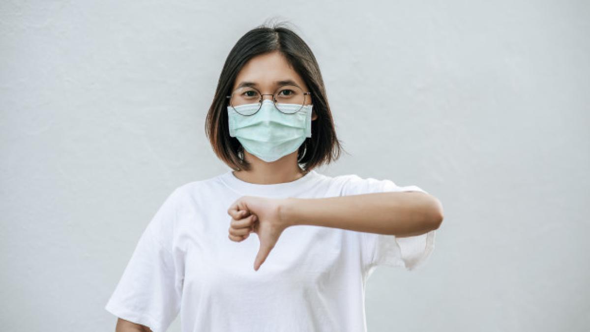 woman_is_wearing_mask_pointing_her_thumb_down_1150_22845_40177100