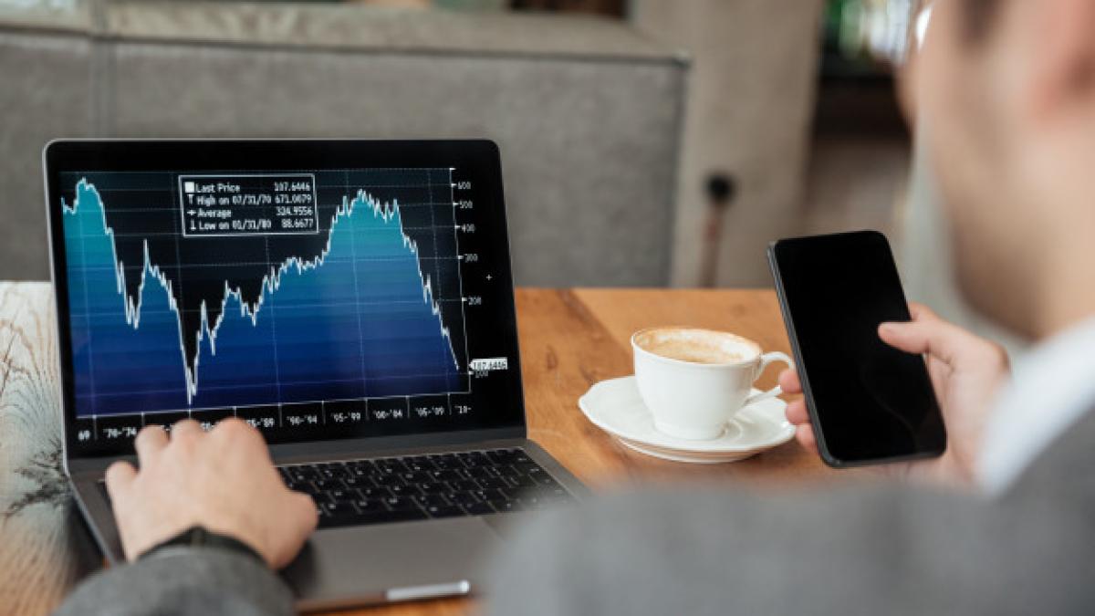 cropped_image_businessman_sitting_by_table_cafe_analyzing_indicators_laptop_computer_while_using_smartphone_171337_5599_74519400