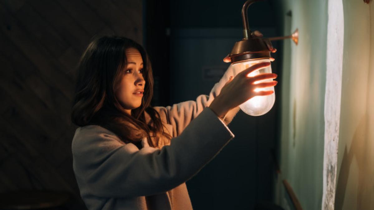 young_beautiful_woman_holds_her_hand_small_wall_lamp_1153_3559_76578600