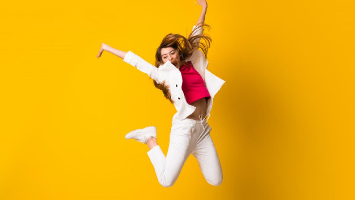 young_woman_jumping_isolated_yellow_wall_1368_43819_25641600