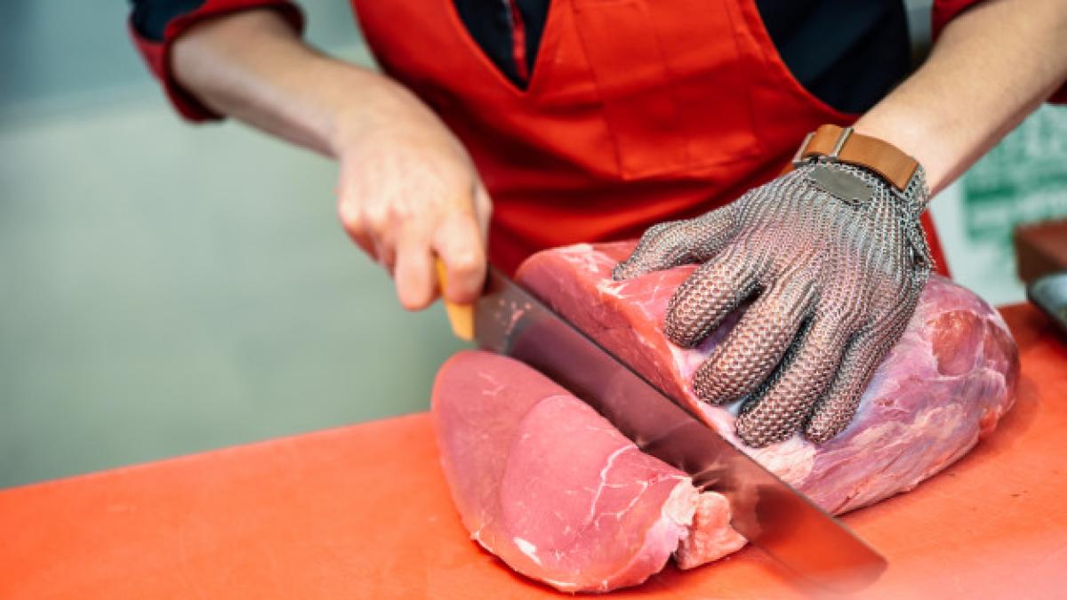 woman_cutting_fresh_meat_butcher_shop_with_metal_safety_mesh_glove_1139_1726_55579800