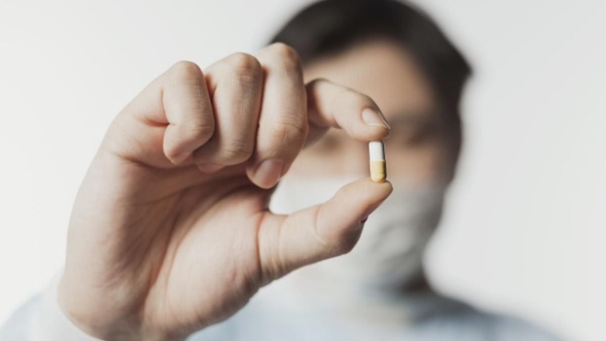 defocused_doctor_holding_up_pill_hand_23_2148450259_39676700