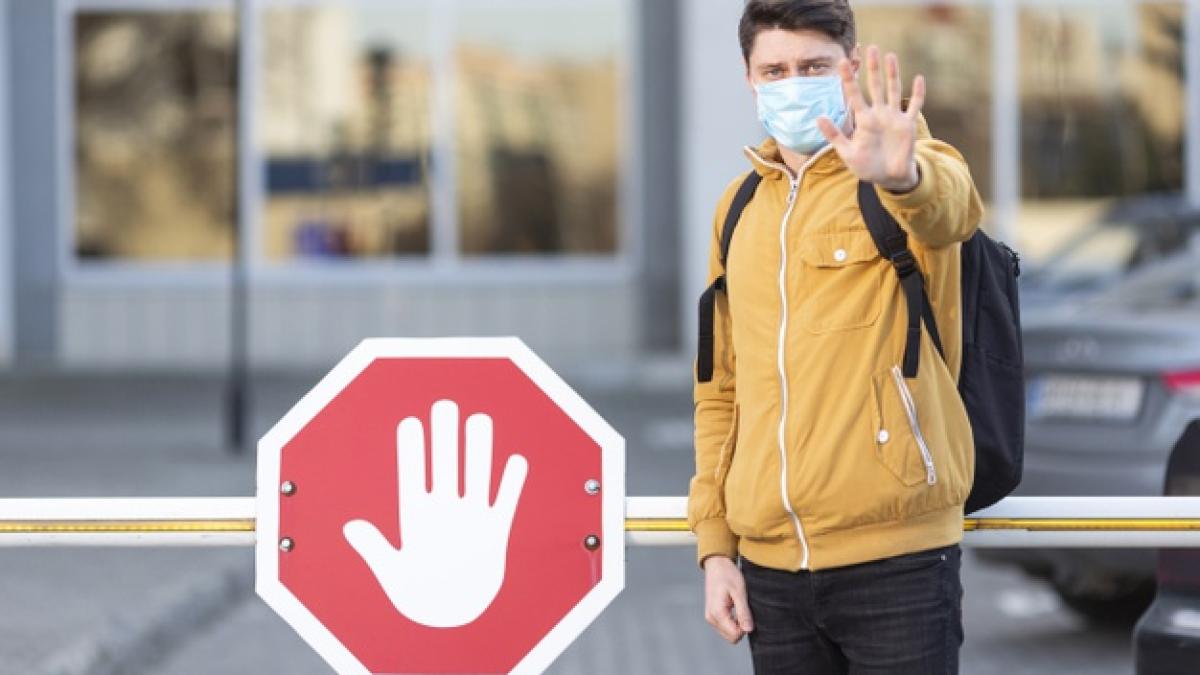 man_with_surgical_mask_with_stop_sign_23_2148483220_95136500