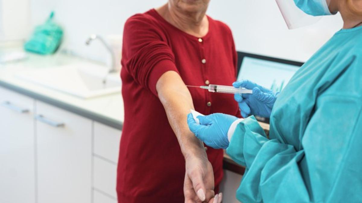 medical_doctor_with_protective_suit_gloves_giving_senior_patient_vaccine_cure_166273_707_94006000