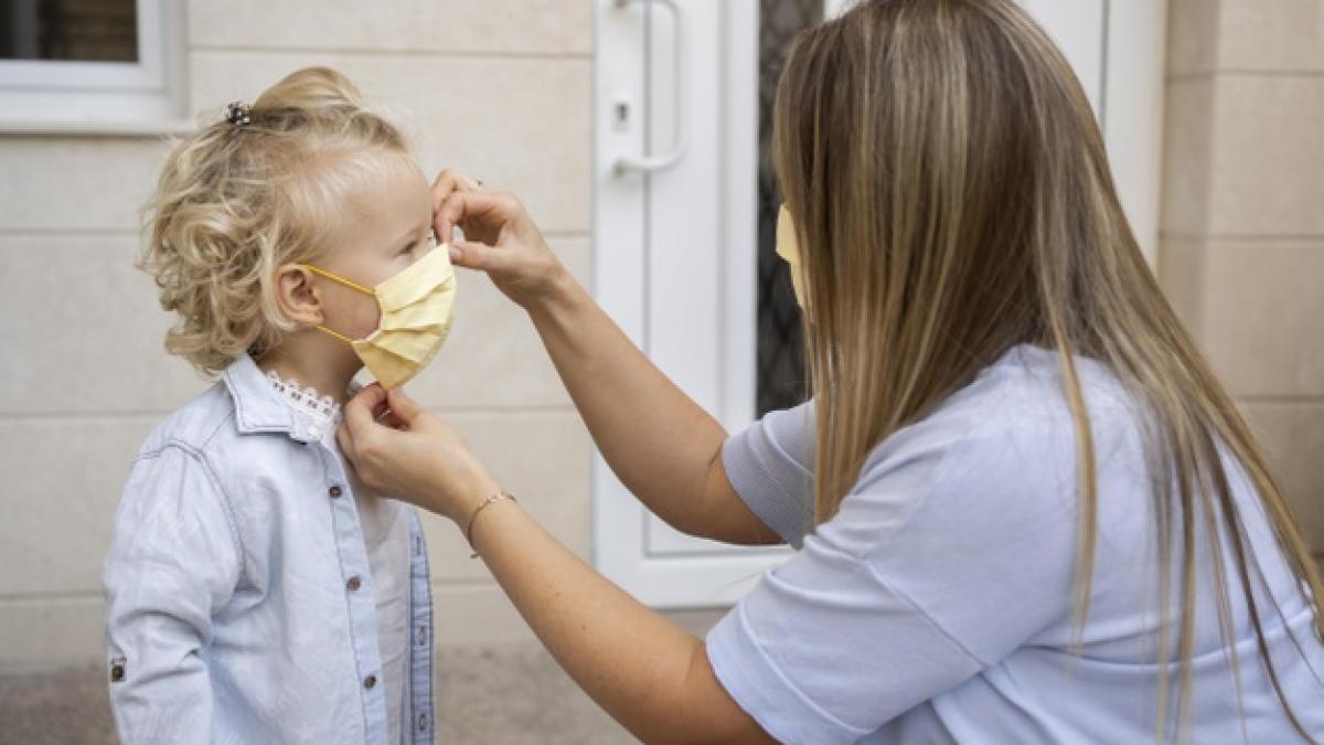side_view_mom_putting_medical_mask_child_23_2148732574_81048100