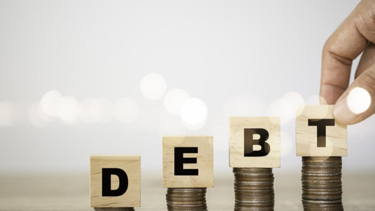 hand_putting_debt_wording_which_are_printed_screen_wooden_cubes_coins_stacking_debt_increasing_concept_50039_1494_72821500