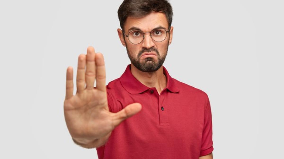 it_s_forbidden_angry_displeased_young_male_frowns_face_shows_stop_gesture_keeps_palm_front_tries_prevent_himeself_from_something_bad_unpleasant_wears_casual_t_shirt_isolated_white_273609_16264_83984500