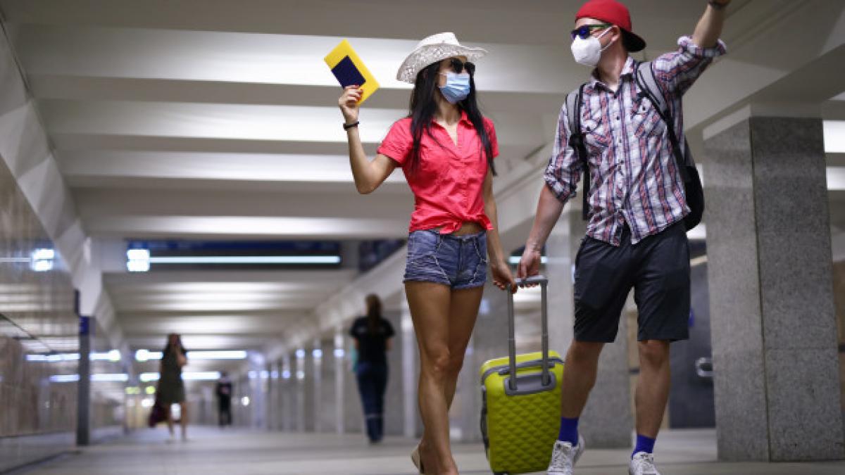 happy_couple_protective_medical_mask_go_tunnel_arport_terminal_hold_passport_hand_portrait_151013_12411_82209800