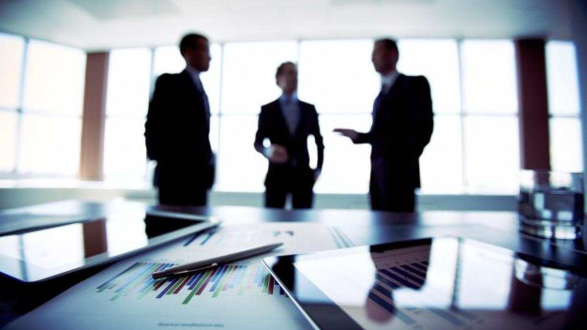 close_up_documents_with_businessmen_blurred_background_1098_2901_63394700