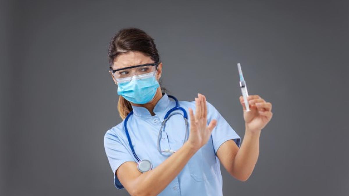 young_female_doctor_holding_syringe_gesturing_like_she_is_against_vaccination_232070_10564_99610200