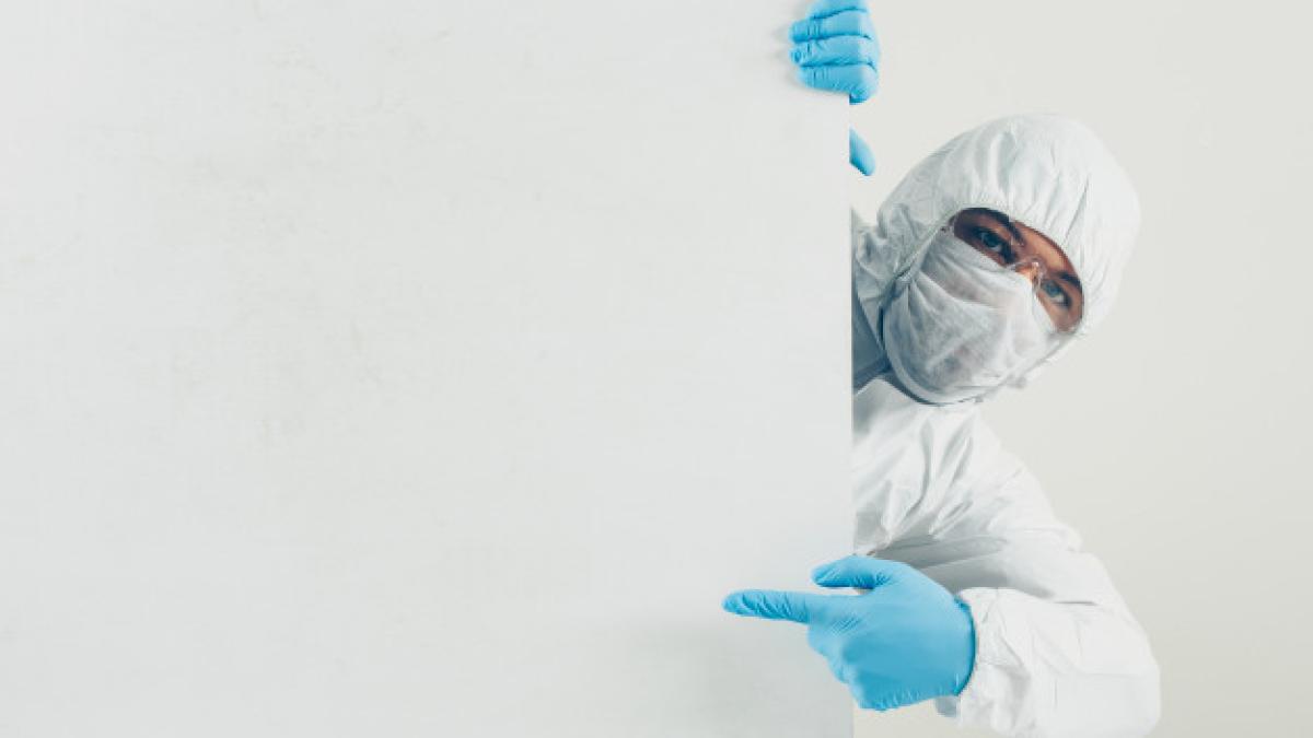 doctor-mask-gloves-protective-suit-pointing-left-looking_176474-3604_73159100