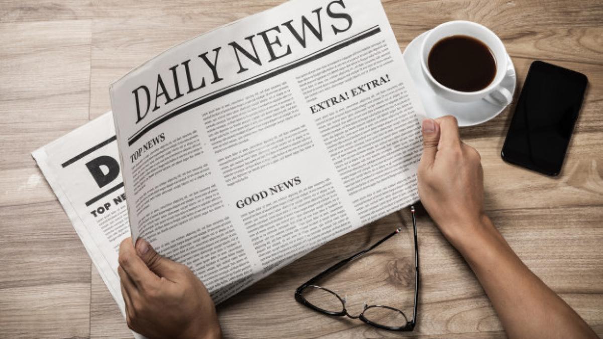 hands-holding-business-newspaper-wooden-table-daily-newspaper-mock-up-concept_185216-20_08745600