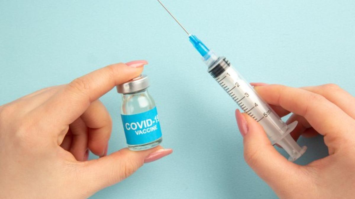 front-view-covid-vaccine-with-female-trying-fill-injection-with-it-blue-background_179666-19324_37751300