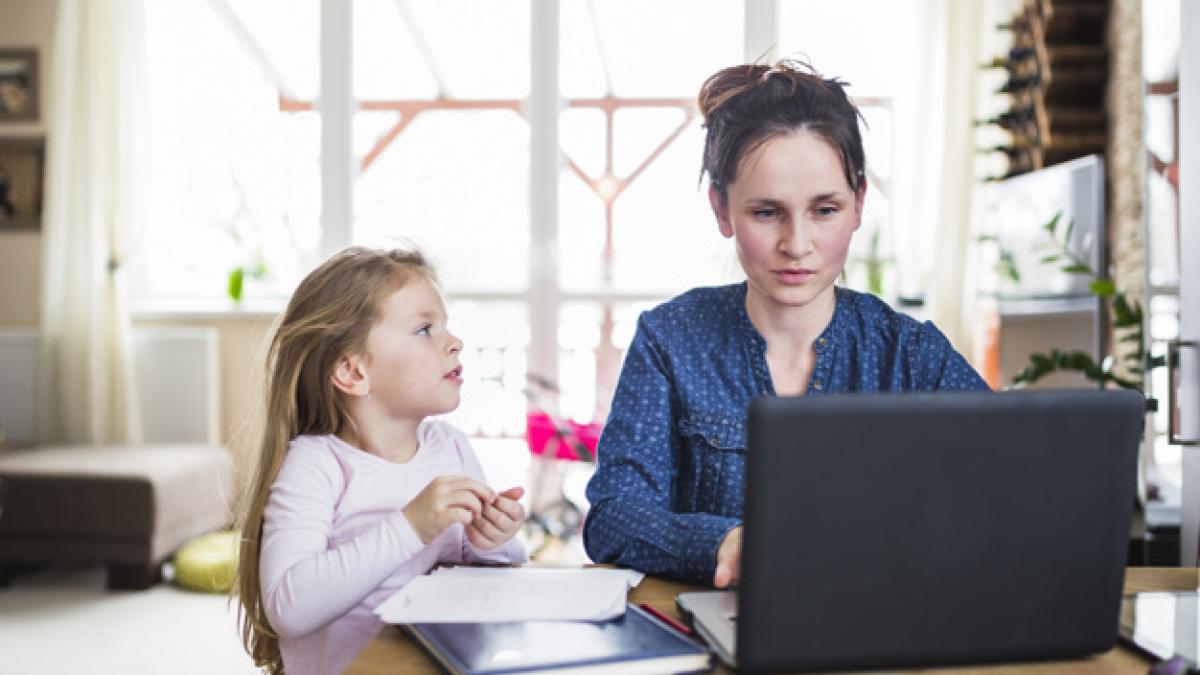 girl-looking-her-mother-working-laptop-wooden-desk_23-2147843584_32927600