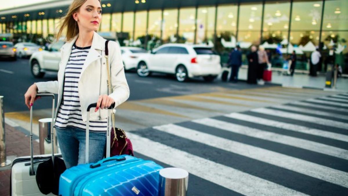 stunning-blonde-lady-with-blue-white-suitcases-stands-before-crossing-street_1304-3038_08100800