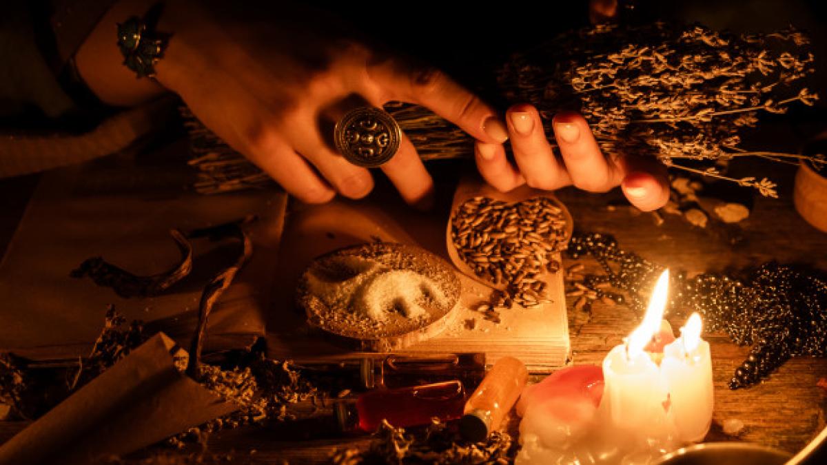 hands-witches-bunch-dry-herbs-divination-light-from-candles-old-magic-table-attributes-occultism-magic_145193-783_27622300