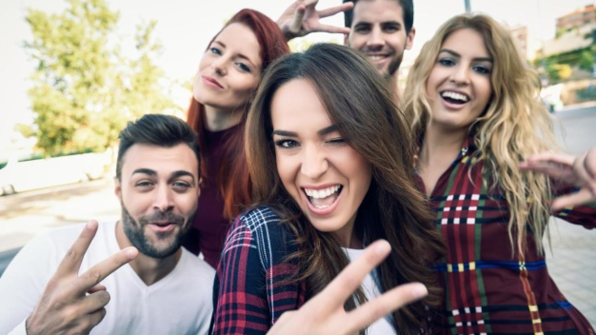 girl-smiling-making-auto-photo-with-her-friends-around_1139-593_64840600