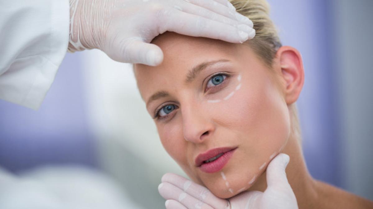 doctor-examining-female-patients-face-cosmetic-treatment_107420-74115_03799500