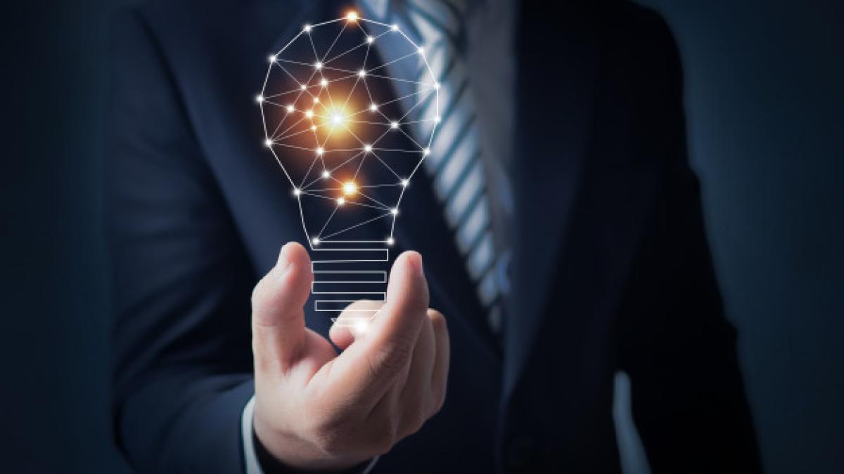 business_man_holding_bright_light_bulb_hand_28629_1091_95493900