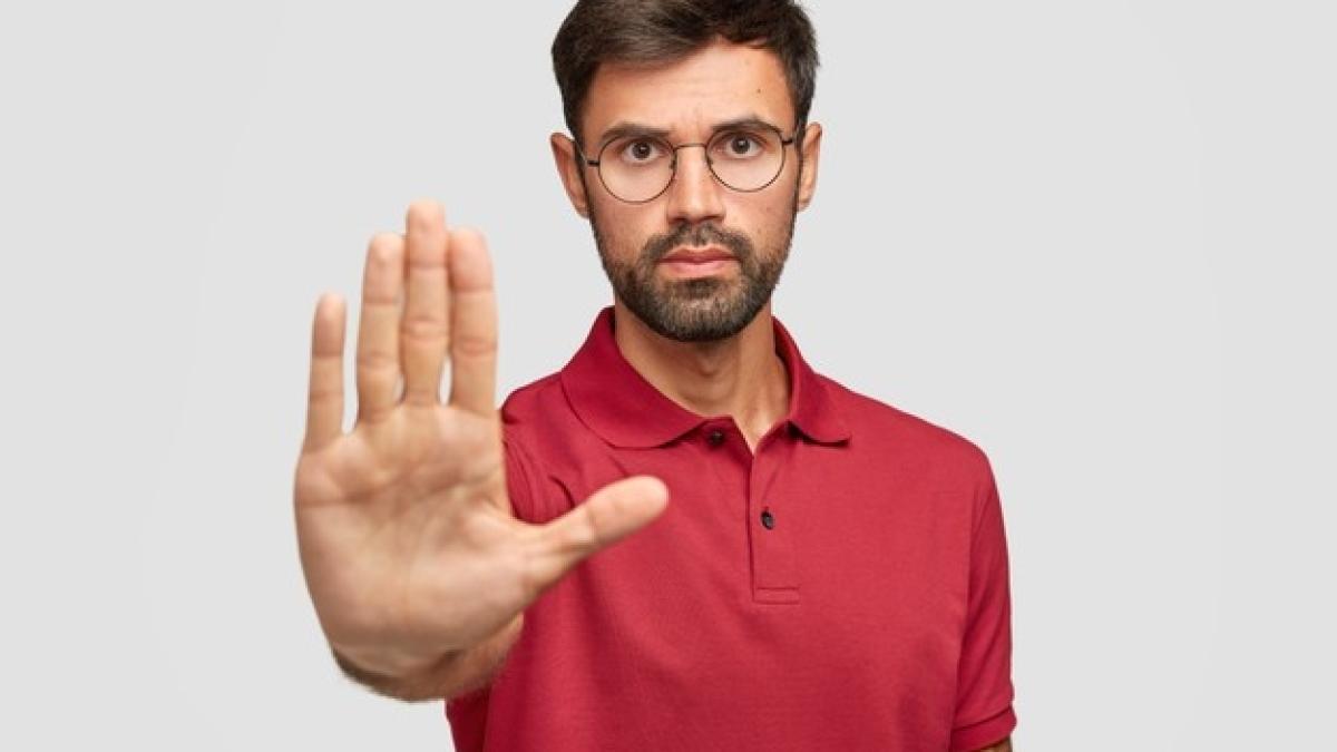 concerned-serious-bearded-man-round-eyewear-pulls-palm-towards-camera-stops-warns-you_273609-18648_47349700