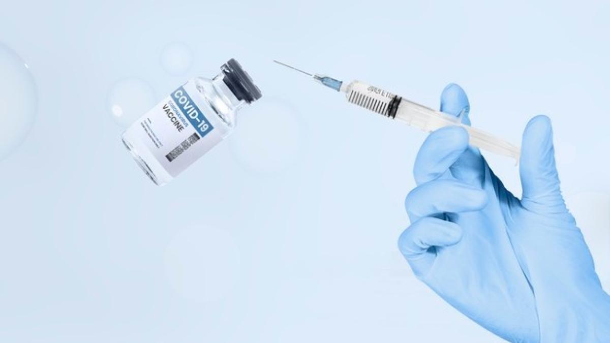 hand-holding-syringe-vaccine-vial_53876-101955_94385100