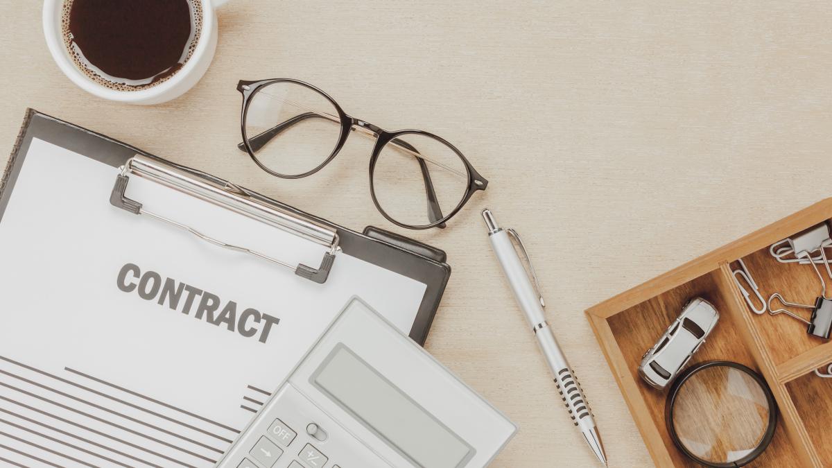 top-view-business-contract-form-with-coffee-eyeglasses-car-calculator-pen-with-magnifying-glass-wooden-background_06156700