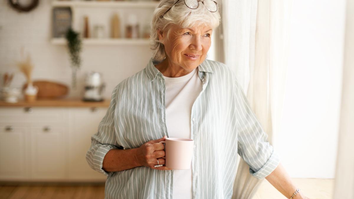 coziness-domesticity-leisure-concept-portrait-stylish-gray-haired-woman-with-round-spectacles-her-head-enjoying-morning-coffee-holding-mug-looking-outside-through-window-glass_07155700