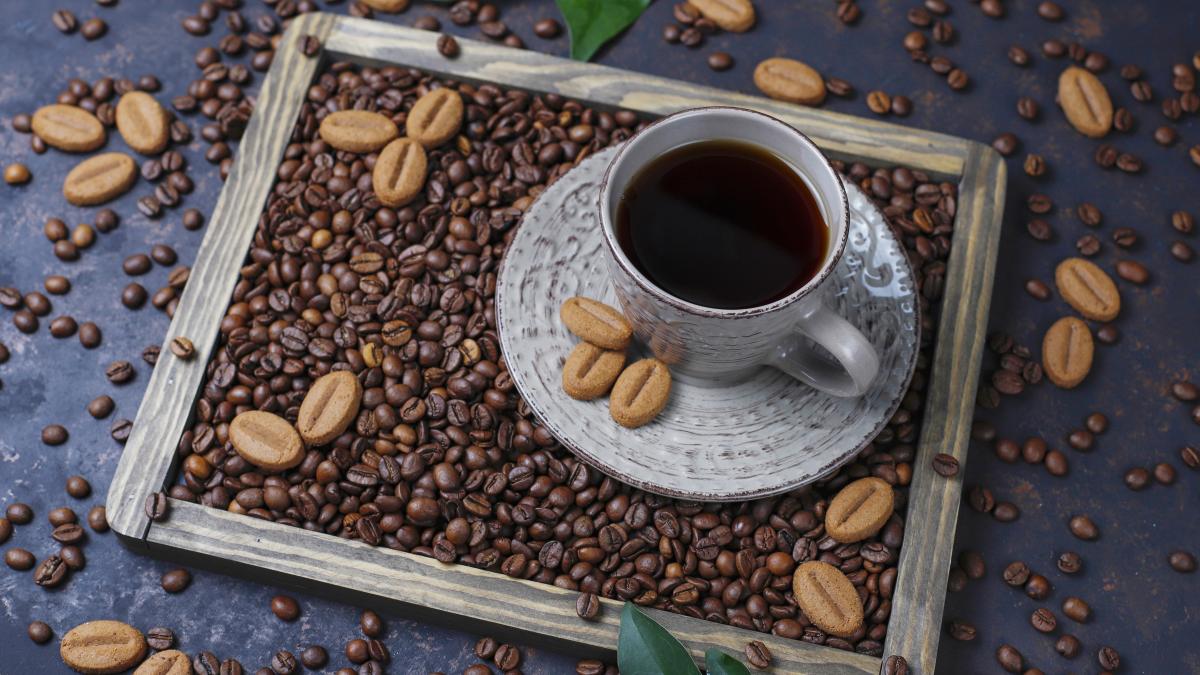 cup-coffee-with-roasted-coffee-beans-coffee-bean-shaped-cookies-dark-surface_91615300