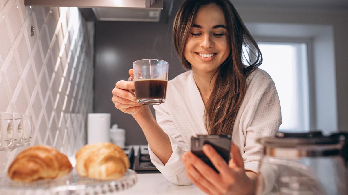 woman-s-morning-with-phone-croissant-coffee-kitchen_27682600