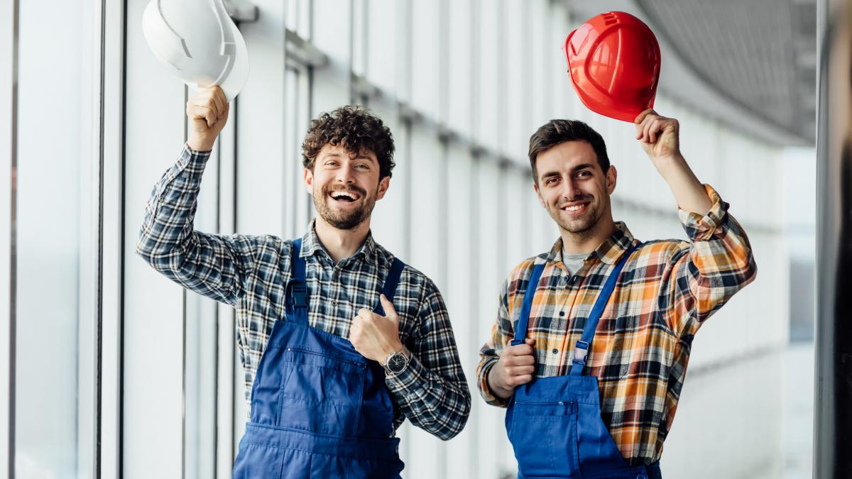 good-looking-construction-worker-sharing-with-experience-with-colleague-holding-helmet_80237700