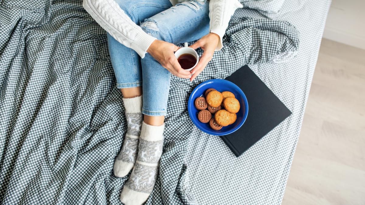 view-from-woman-sitting-bed-morning-drinking-coffee-cup-eating-cookies-breakfast_36902000
