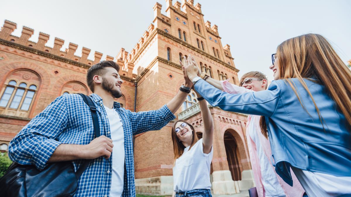 low-angle-cheerful-team-students-passed-test-by-preparing-all-together_60657600