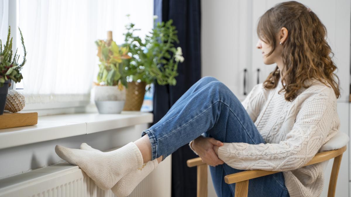 full-shot-woman-sitting-near-heater_12349900