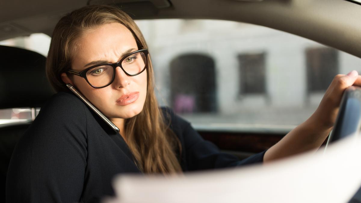 young-serious-businesswoman-black-dress-eyeglasses-talking-cellphone-thoughtfully-looking-documents-while-sitting-wheel-car_26000300