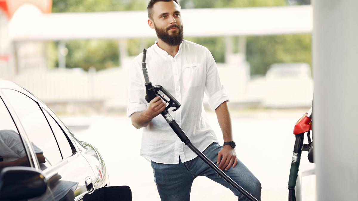 handsome-man-pours-gasoline-into-tank-car_23913500