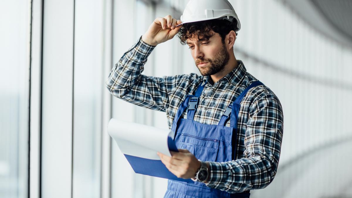 happy-young-man-architect-hard-hat-holding-folder_48231000