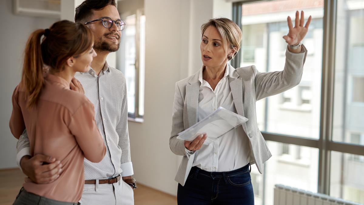 young-couple-communicating-with-real-estate-agent-while-buying-their-new-home-focus-is-agent_37682000