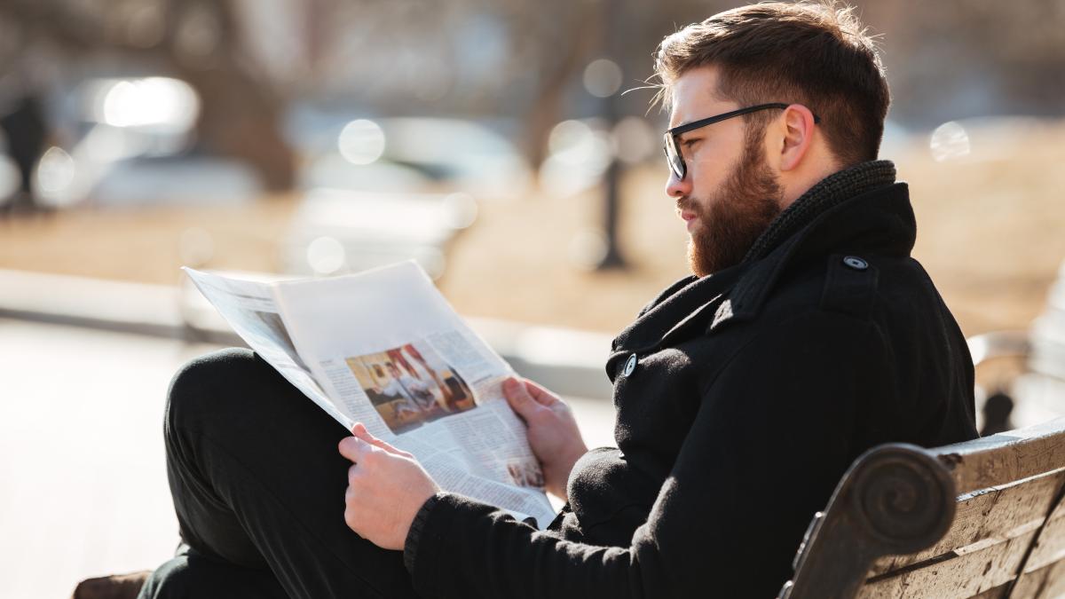 man-glasses-sitting-reading-newspaper-city_62299800