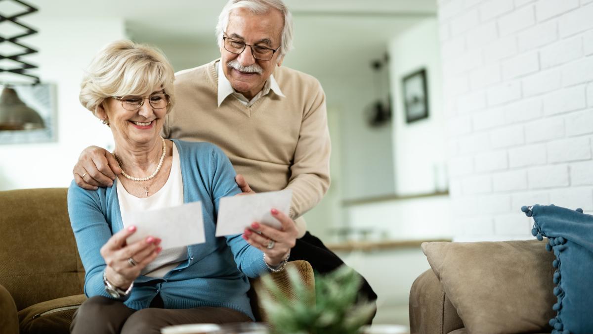 happy-mature-woman-her-husband-looking-their-photos-while-relaxing-home_24460000