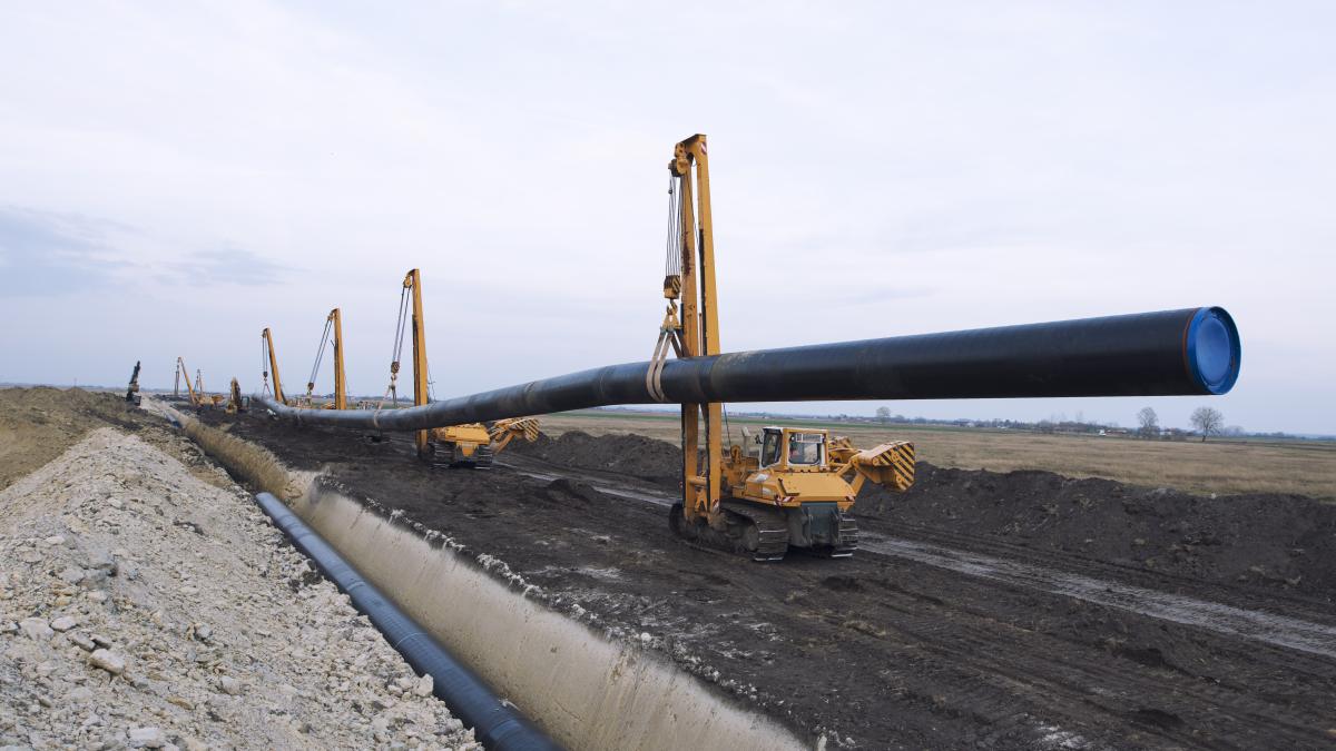 heavy-duty-construction-machines-carrying-placing-gas-pipe-into-ground_36884700